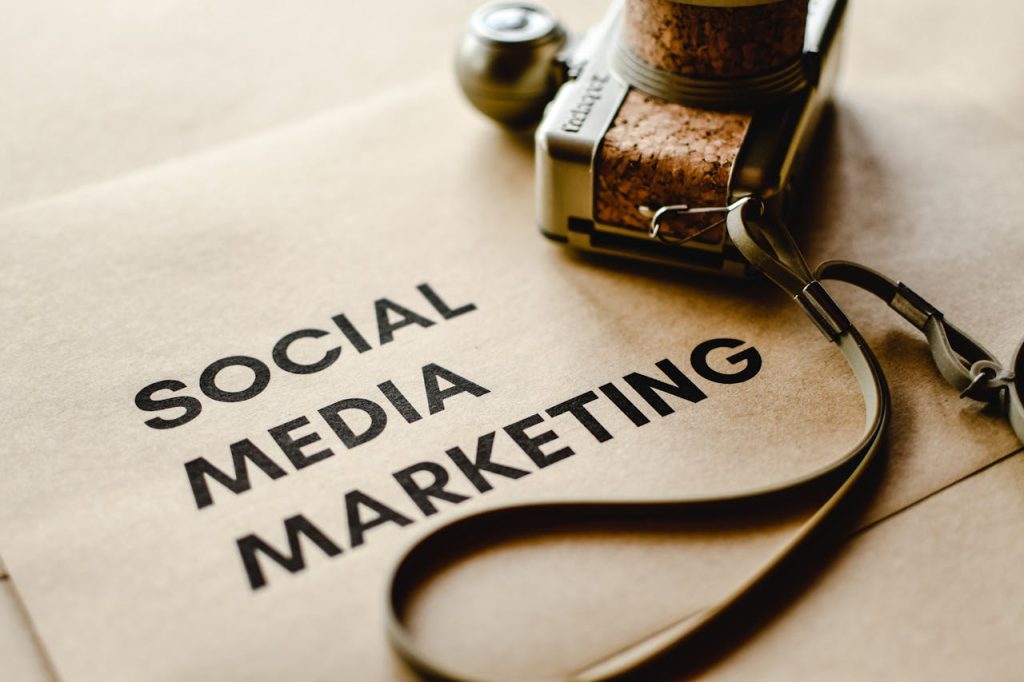 pexels-photo-6956303 Close-up of a camera placed on brown paper with 'Social Media Marketing' text, emphasizing digital marketing themes.